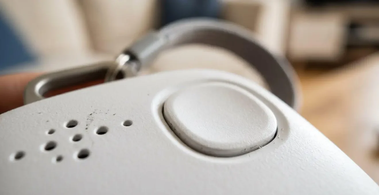 Macro detail of automatic fall detection pendant showing textured surface and button mechanism